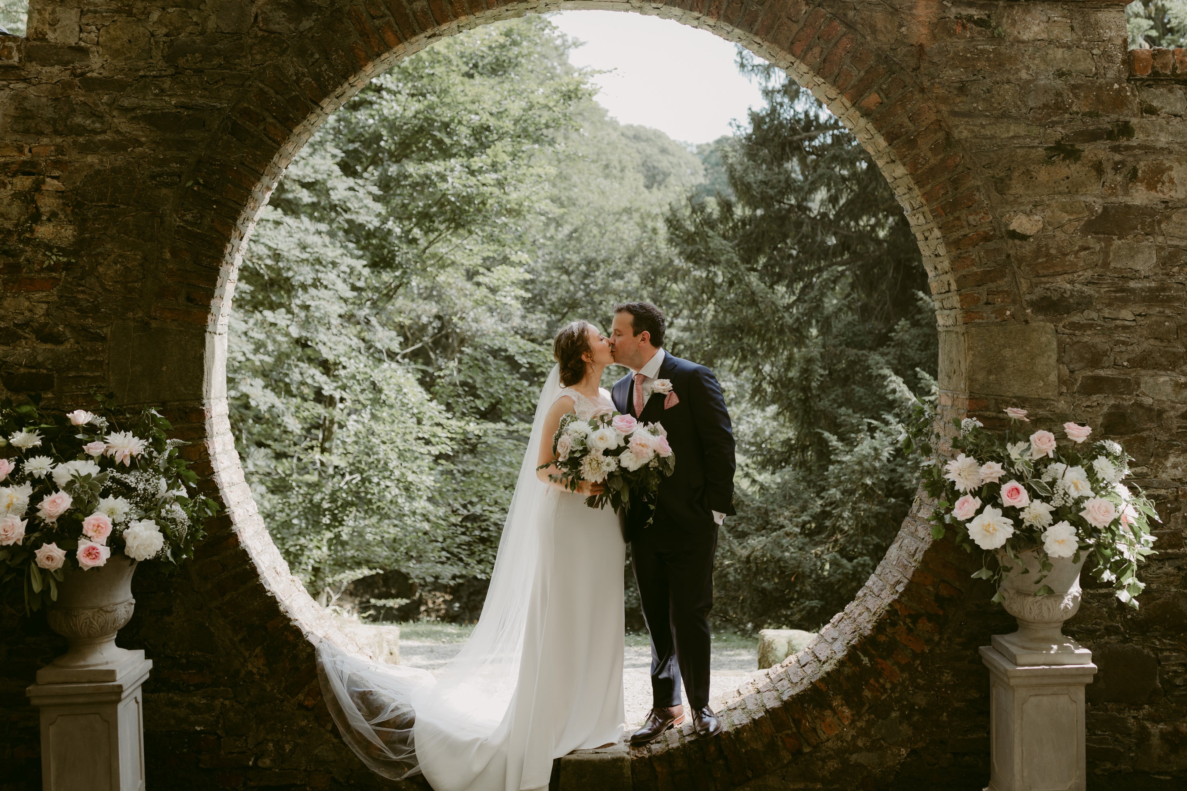 Bride and groom with beautiful wedding flowers and arrangements in pink and white roses 